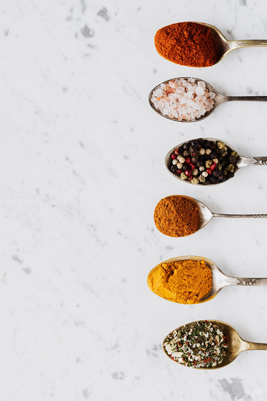 Spoons with spices. Spices that would make your chicken recipes even spicier.